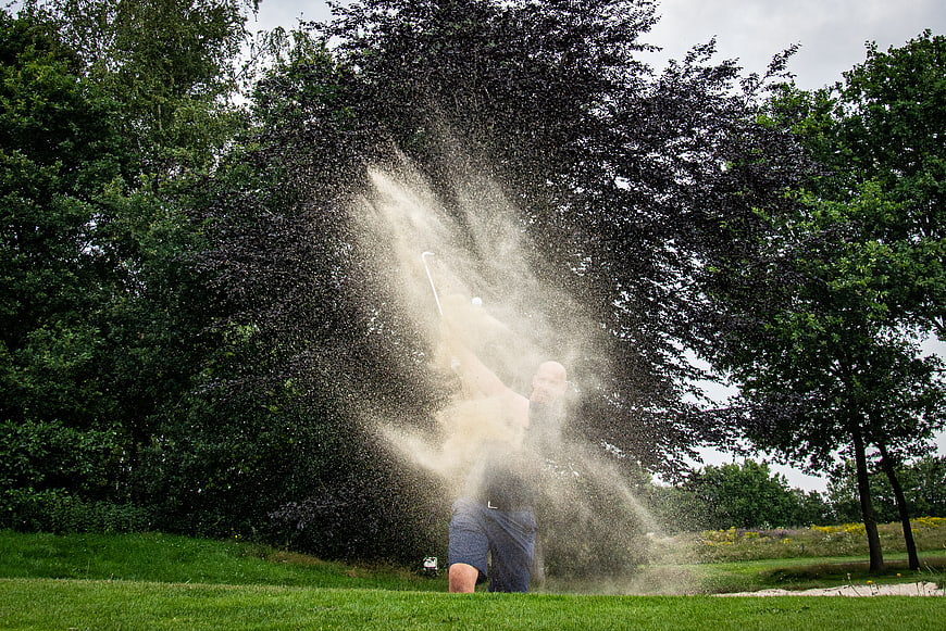 Golfer Hitting Ball Out of Sand Bunker