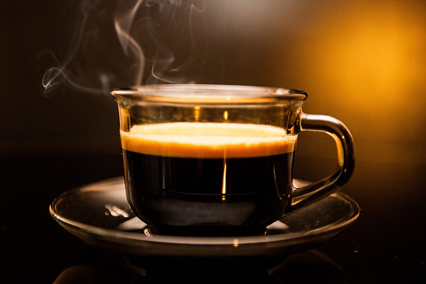 Steaming Hot Espresso in Glass Cup on Dark Background