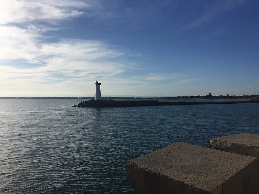 White Lighthouse on Breakwater with Blue Sky and Sea