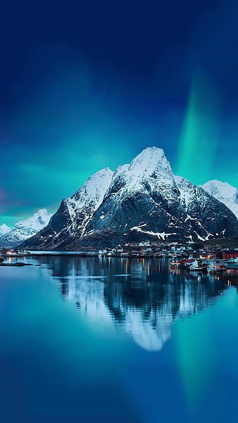 Snowy Mountain Peak With Aurora Borealis And Village Reflection