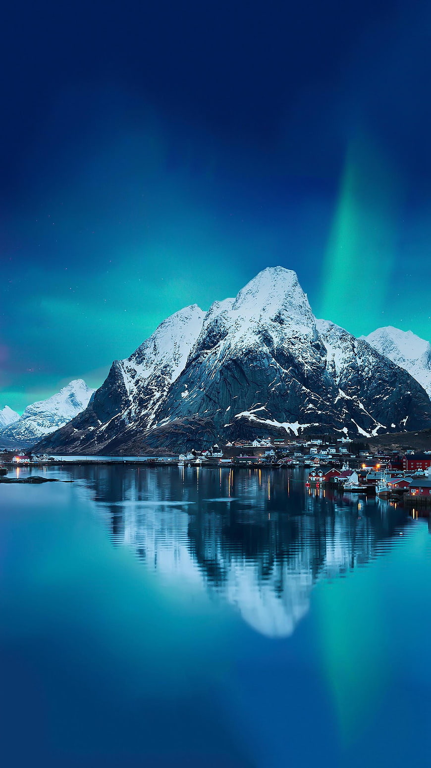 Snowy Mountain Peak With Aurora Borealis And Village Reflection