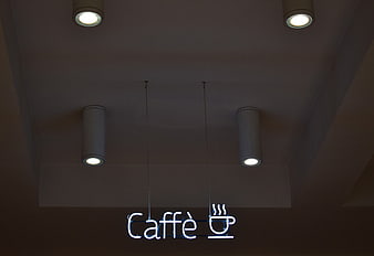Neon Caffe Sign Hanging from Ceiling with Spotlights
