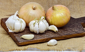 Raw Onions and Garlic Bulbs on Rustic Wooden Cutting Board