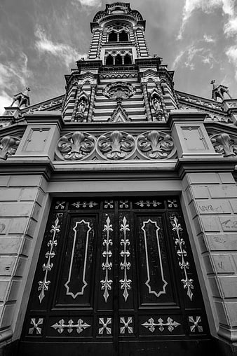 Low angle black and white church facade with ornate doors