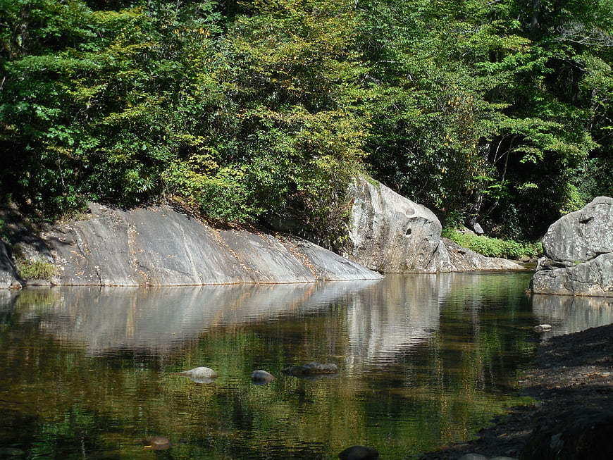 Serene River Flowing Past Large Granite Boulders in Forest