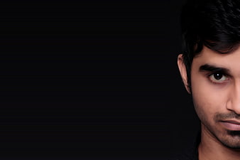 Close-up portrait of a young man with dramatic lighting on black background