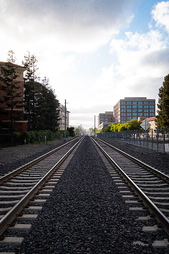 Straight Railroad Tracks Leading to Urban Cityscape