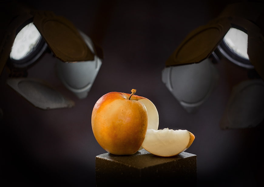 Red apple on pedestal with studio lights background