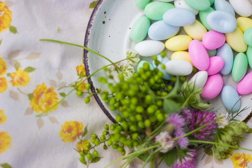 Pastel Easter Eggs and Spring Flowers on Floral Tablecloth