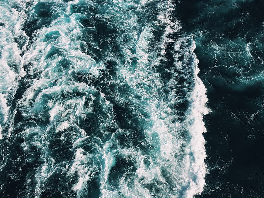 Aerial View of Turbulent Ocean Waves and White Sea Foam