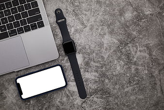 Flat lay of laptop, smartphone, and smartwatch on concrete