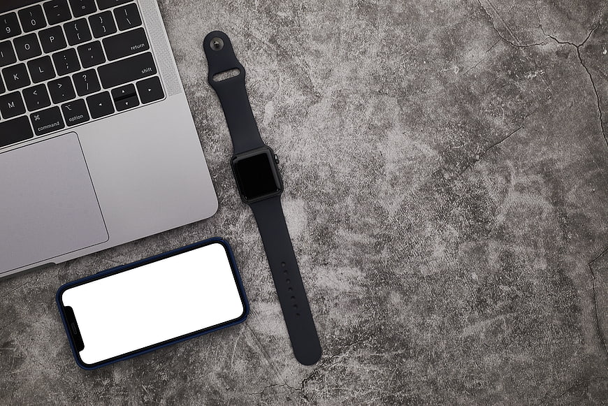 Flat lay of laptop, smartphone, and smartwatch on concrete