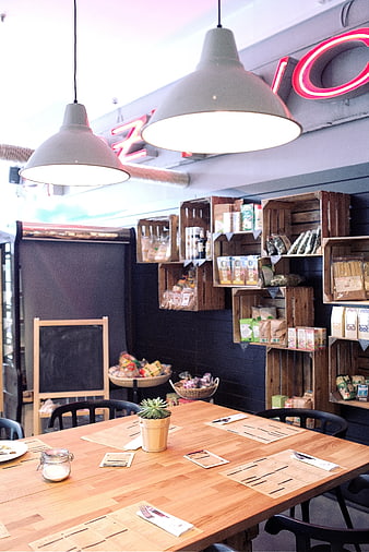 Modern rustic restaurant interior with wooden crates and neon sign