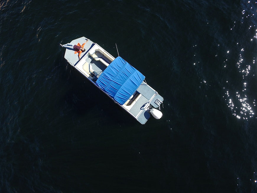 Aerial view of a person relaxing on a boat in the ocean