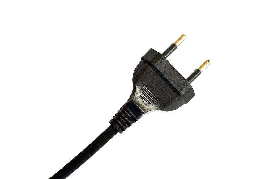 Black European electrical plug with gold pins on white background
