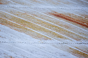 Close-up of weathered corrugated metal with rust streaks