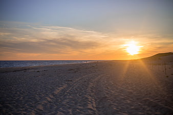 Serene Beach Sunset with Golden Sunlight and Sandy Shore