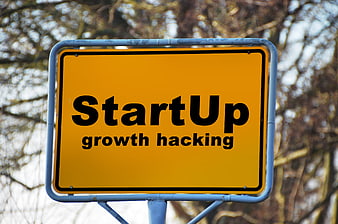Yellow road sign with StartUp growth hacking text