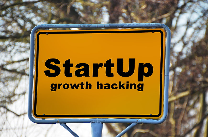 Yellow road sign with StartUp growth hacking text