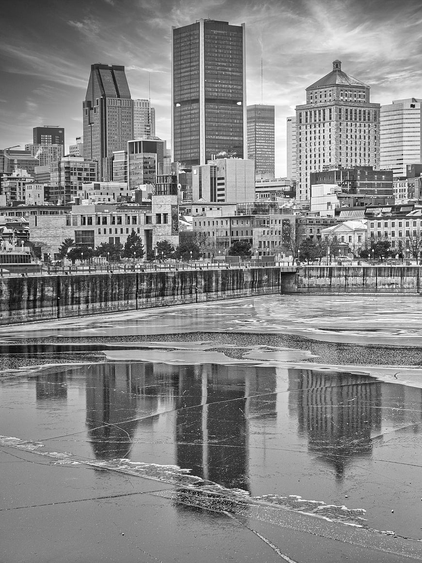 Black and white cityscape with frozen river reflections