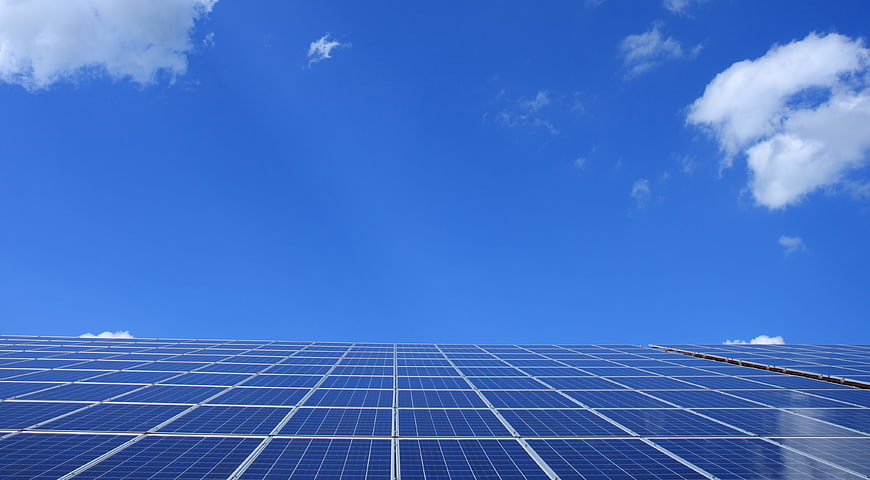 Solar Panels Under Blue Sky with White Clouds