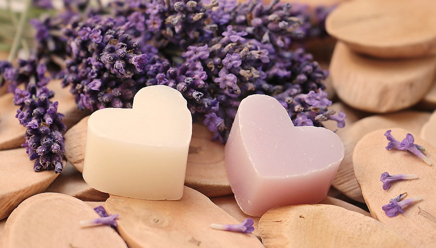 Heart-shaped lavender soaps on wooden slices with dried flowers