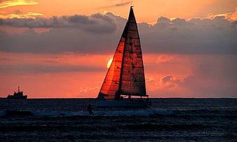 Sailboat Silhouette Against Vibrant Orange Sunset Sky