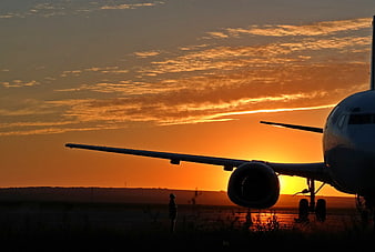 Airplane Silhouette Against Vibrant Orange Sunrise Sky