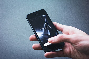 Hand holding smartphone displaying Uber app interface