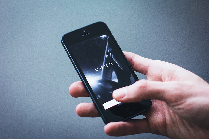 Hand holding smartphone displaying Uber app interface