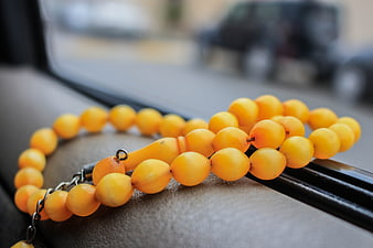 Yellow Amber Prayer Beads on Car Dashboard