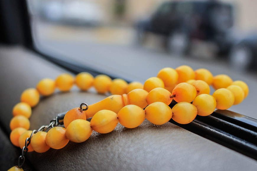 Yellow Amber Prayer Beads on Car Dashboard