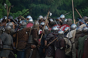 Medieval warriors in armor clashing with swords and shields