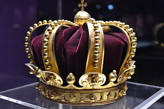 Golden royal crown with purple velvet on display