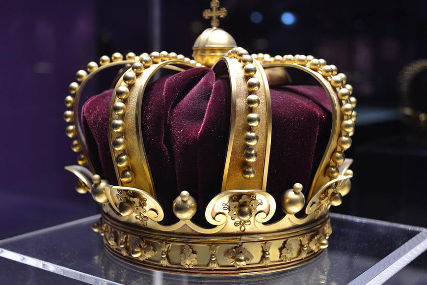 Golden royal crown with purple velvet on display