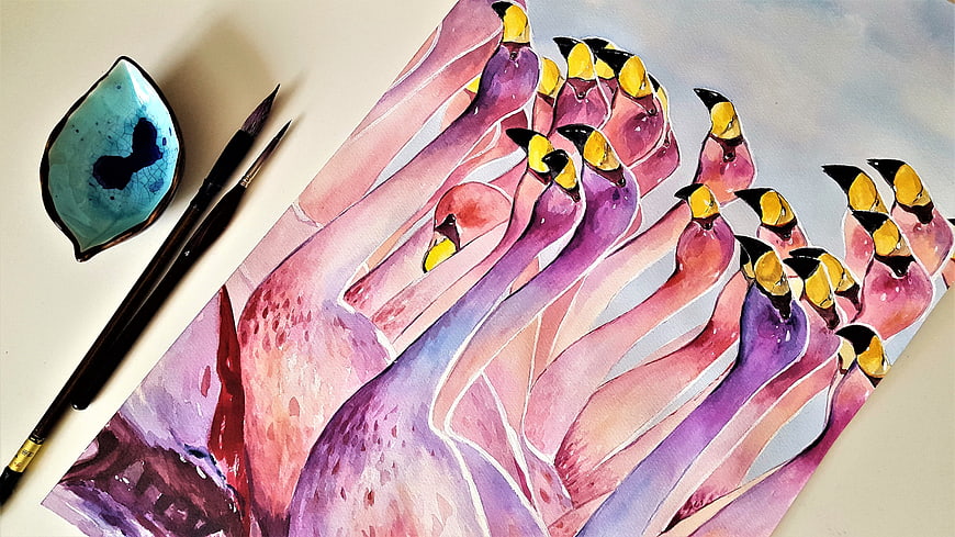 Watercolor painting of pink flamingos with brushes and palette