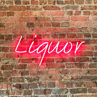 Red Neon Liquor Sign on Exposed Brick Wall