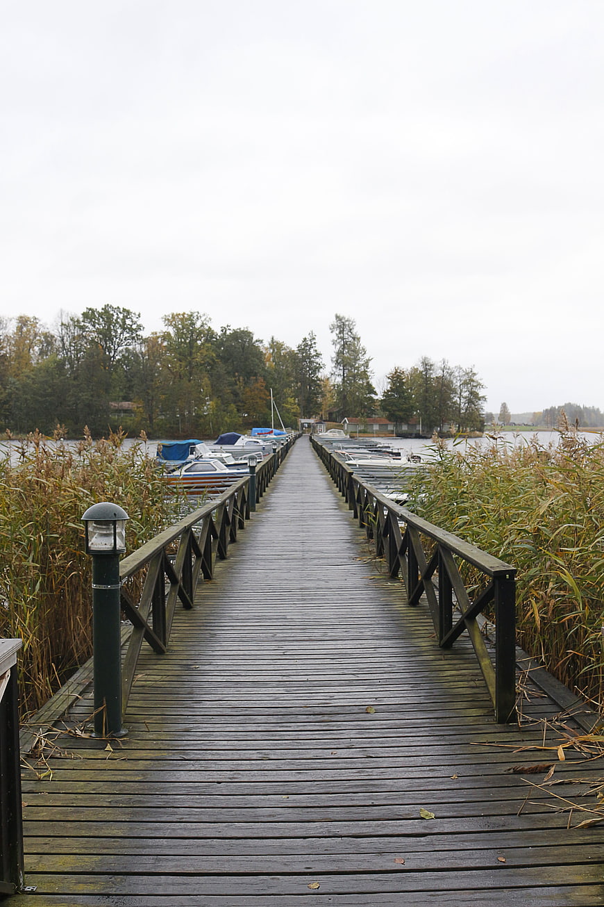 Wooden Pier Extending Over Lake with Moored Boats