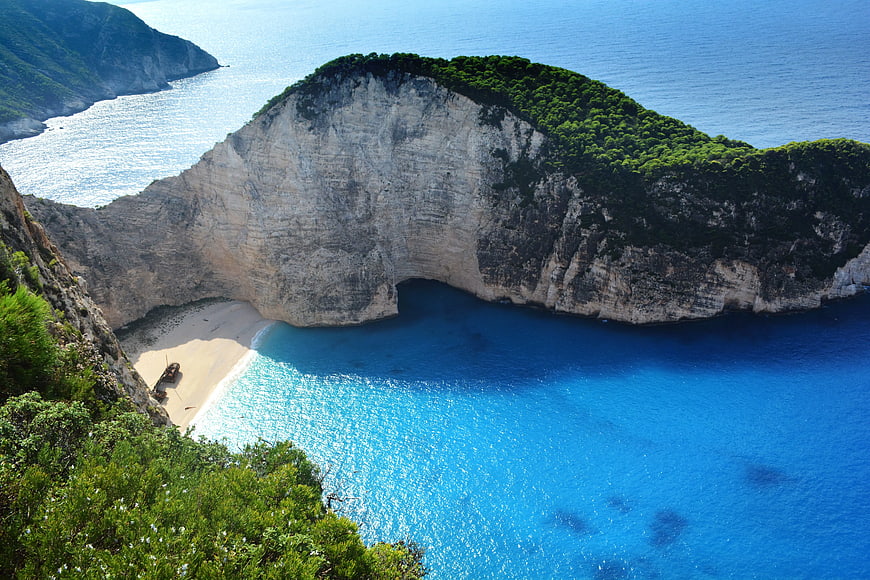 Aerial View of Shipwreck Beach with Cliffs and Blue Water