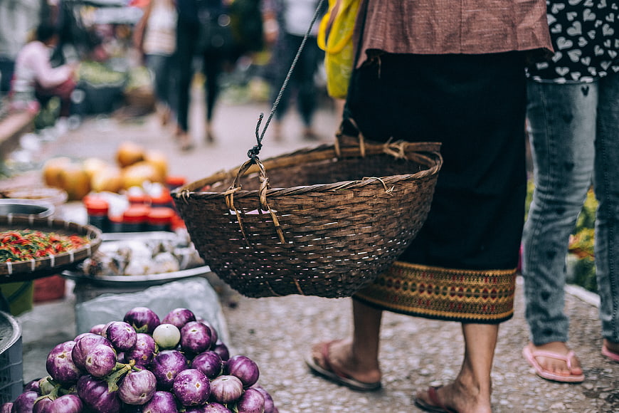 Woman Carrying Woven Basket at Outdoor Vegetable Market