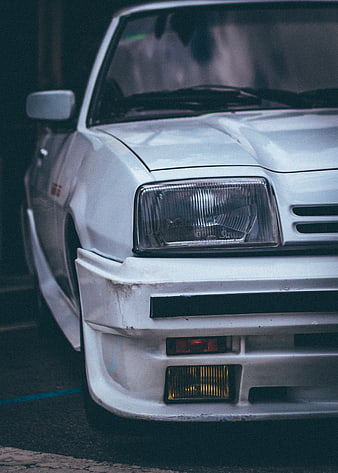 Close-up of vintage white modified car front bumper and headlight