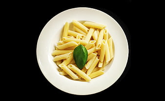 Top View of Uncooked Penne Pasta on White Plate