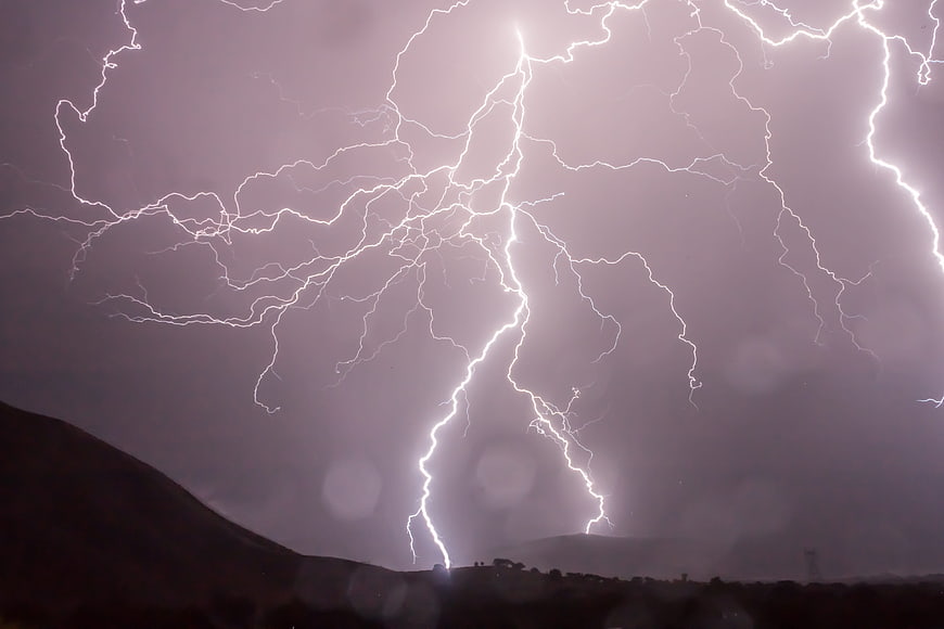 Dramatic Lightning Strike Over Dark Mountain Landscape