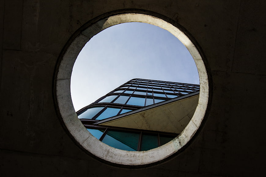 Modern Glass Building Viewed Through Circular Concrete Opening