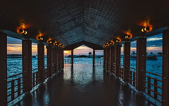 Covered wooden pier at sunset with ocean view