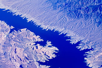 Aerial view of deep blue fjord surrounded by rugged mountains