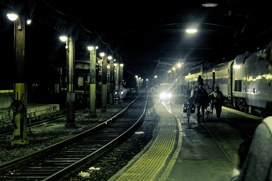 Night scene at a railway station with trains and cyclists