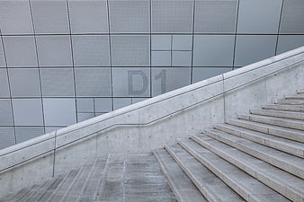 Modern concrete staircase with perforated metal wall facade