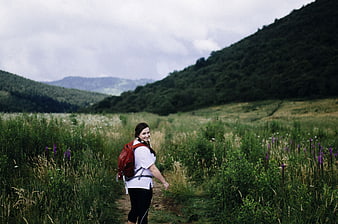 Woman Hiking on Mountain Trail in Green Valley
