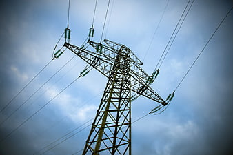 Low angle view of high voltage electricity pylon against cloudy sky